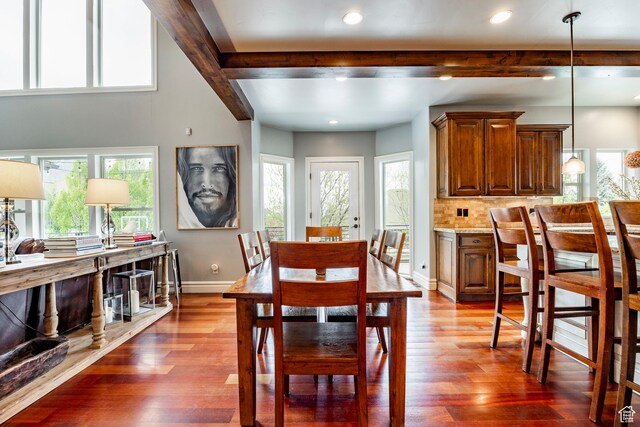dining space with beamed ceiling and wood-type flooring