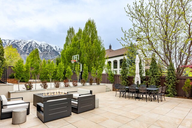 view of patio / terrace featuring an outdoor living space with a fire pit and a mountain view