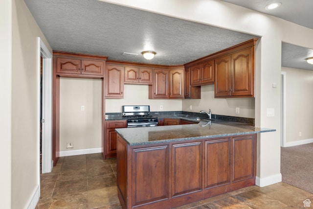 885 S Southflat Rd, Huntington, UT 84528 - kitchen featuring stainless steel range with gas cooktop, dark stone countertops, a textured ceiling, dark tile flooring, and sink