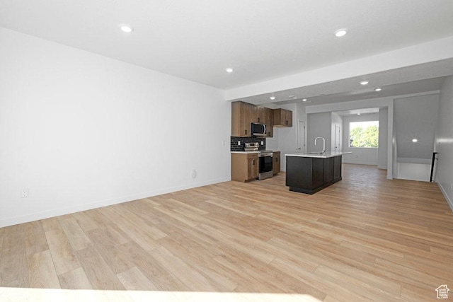 4126 S Winder Ward Dr Unit 2-123, Millcreek, UT 84124 - kitchen featuring stainless steel appliances, a sink, light countertops, open floor plan, and light wood-style flooring