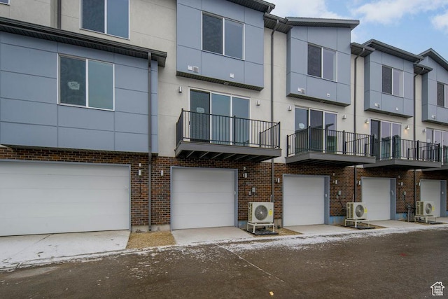 4126 S Winder Ward Dr Unit 2-123, Millcreek, UT 84124 - view of front facade with a garage, stucco siding, and ac unit