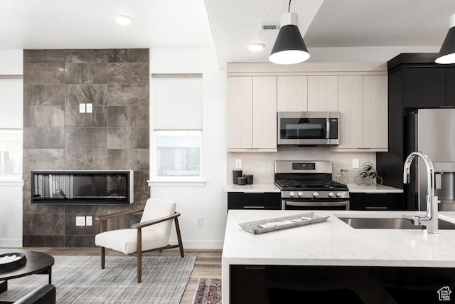 4126 S Winder Ward Dr Unit 2-123, Millcreek, UT 84124 - kitchen featuring appliances with stainless steel finishes, a sink, modern cabinets, and decorative light fixtures