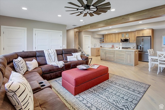 living room featuring beamed ceiling, ceiling fan, and light hardwood / wood-style flooring