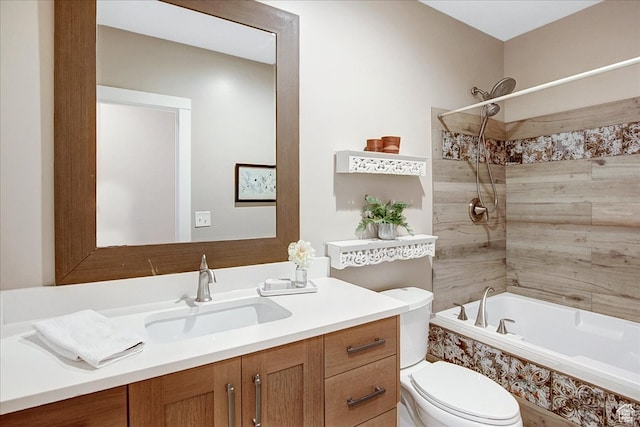 full bathroom featuring tiled shower / bath combo, vanity, and toilet