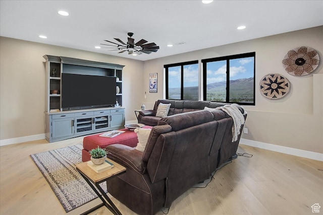 living room with light wood-type flooring and ceiling fan