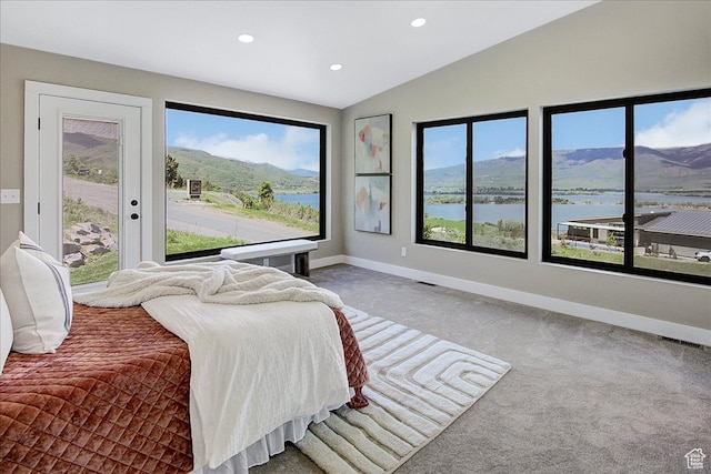 bedroom with multiple windows, carpet flooring, lofted ceiling, and a water and mountain view