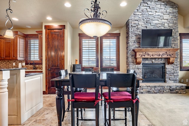 1621 E Abajo Peak Ct, Heber City, UT 84032 - tiled dining room featuring sink, a textured ceiling, and a fireplace