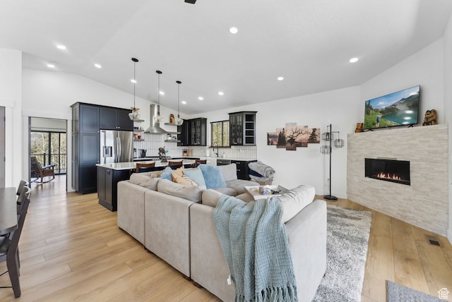 1430 W Arapaho Dr Unit 59, Coalville, UT 84017 - living room with a fireplace, light hardwood / wood-style flooring, high vaulted ceiling, and sink