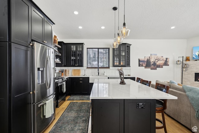 1430 W Arapaho Dr Unit 59, Coalville, UT 84017 - kitchen featuring sink, a kitchen breakfast bar, stainless steel appliances, light stone counters, and a kitchen island