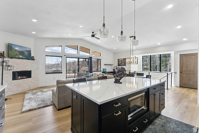 1430 W Arapaho Dr Unit 59, Coalville, UT 84017 - kitchen featuring pendant lighting, light hardwood / wood-style flooring, a kitchen island, built in microwave, and vaulted ceiling