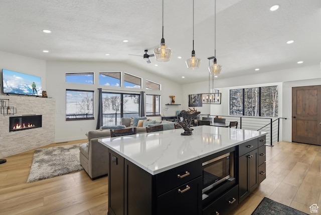 1430 W Arapaho Dr Unit 59, Coalville, UT 84017 - kitchen featuring decorative light fixtures, black microwave, a center island, a textured ceiling, and light hardwood / wood-style flooring