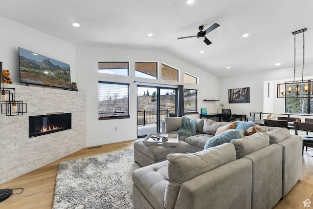1430 W Arapaho Dr Unit 59, Coalville, UT 84017 - living room with ceiling fan with notable chandelier, lofted ceiling, a stone fireplace, and light hardwood / wood-style floors