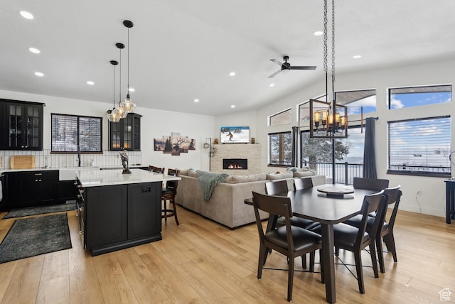 1430 W Arapaho Dr Unit 59, Coalville, UT 84017 - dining area featuring ceiling fan, a stone fireplace, lofted ceiling, and light hardwood / wood-style floors