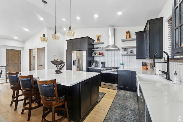 1430 W Arapaho Dr Unit 59, Coalville, UT 84017 - kitchen with a kitchen island, appliances with stainless steel finishes, decorative light fixtures, light stone counters, and wall chimney exhaust hood
