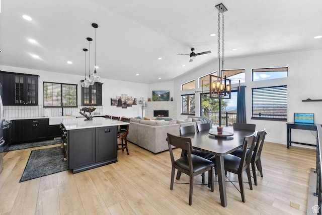 1430 W Arapaho Dr Unit 59, Coalville, UT 84017 - kitchen with a stone fireplace, pendant lighting, a kitchen bar, a center island, and light hardwood / wood-style flooring