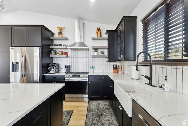 1430 W Arapaho Dr Unit 59, Coalville, UT 84017 - kitchen featuring lofted ceiling, backsplash, light stone counters, stainless steel appliances, and wall chimney range hood