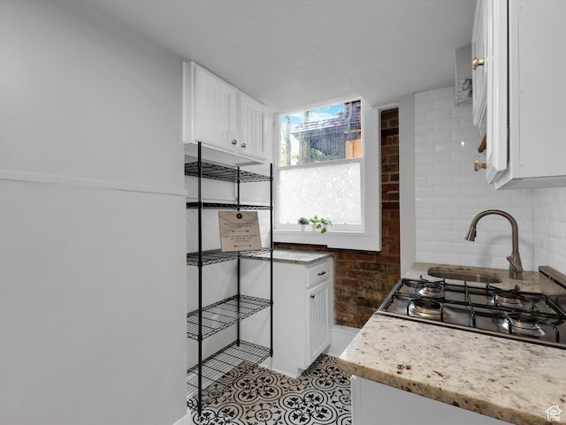 86 B St E Unit 10, Salt Lake City, UT 84103 - kitchen featuring decorative backsplash, light stone counters, white cabinetry, and stainless steel gas cooktop