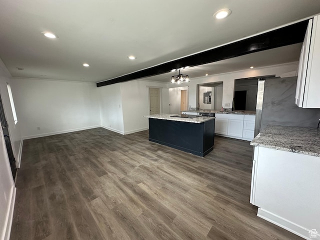 kitchen with beamed ceiling, white cabinets, a kitchen island, dark wood-type flooring, and stainless steel fridge