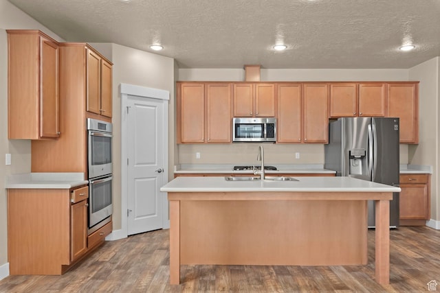 93 E 425 N, Vineyard, UT 84059 - kitchen featuring light countertops, a textured ceiling, a center island with sink, stainless steel appliances, and wood finished floors