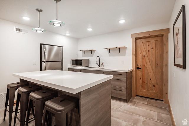 3009 E Black Forest Rd, Sundance, UT 84604 - kitchen with stainless steel appliances, hanging light fixtures, sink, and a kitchen bar