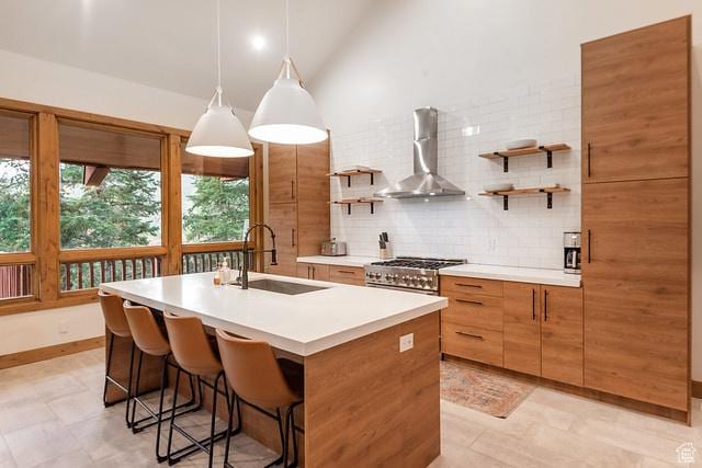 3009 E Black Forest Rd, Sundance, UT 84604 - kitchen featuring wall chimney exhaust hood, high end stainless steel range, sink, pendant lighting, and a kitchen island with sink