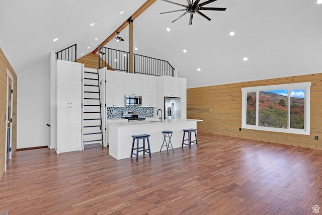 999 Cisco Run, Garden City, UT 84028 - living room featuring high vaulted ceiling, a ceiling fan, wooden walls, light wood-style flooring, and recessed lighting