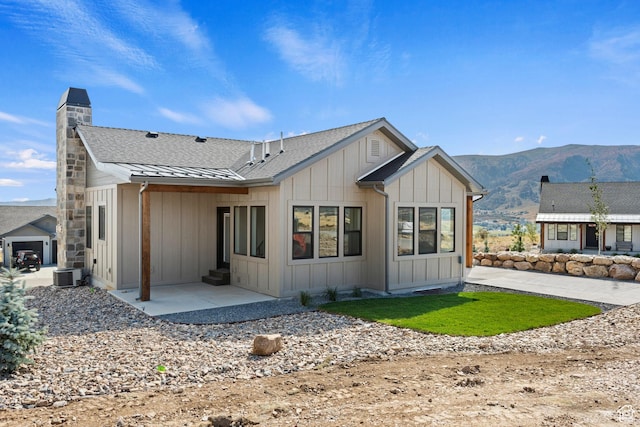 4778 Paddleford Dr Unit 227, Eden, UT 84310 - rear view of property with board and batten siding, a mountain view, a chimney, a patio area, and a standing seam roof
