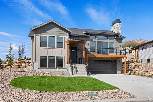 4778 Paddleford Dr Unit 227, Eden, UT 84310 - contemporary house featuring a chimney, driveway, an attached garage, board and batten siding, and a balcony