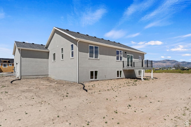 rear view of house featuring stucco siding and a mountain view