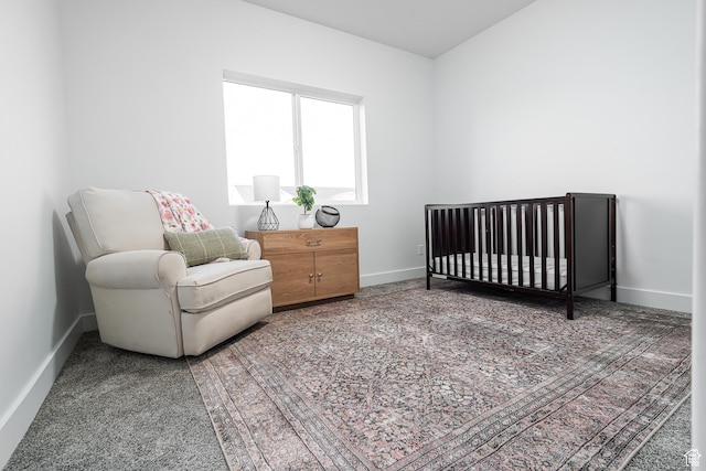 carpeted bedroom featuring baseboards and a nursery area