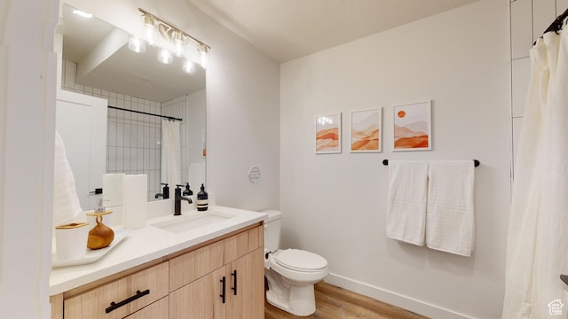 bathroom with toilet, vanity, and hardwood / wood-style flooring
