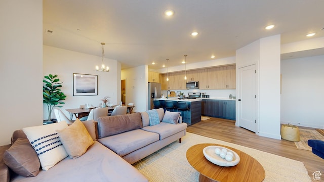 living room featuring a notable chandelier and light hardwood / wood-style flooring