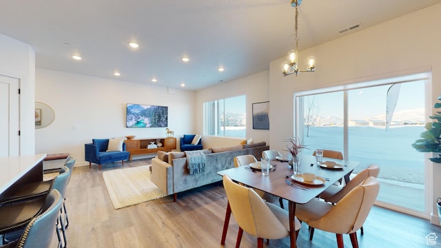 dining area with a chandelier and light hardwood / wood-style floors