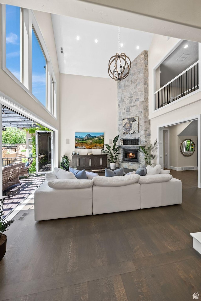 14234 S Canyon Vine Cv E, Draper, UT 84020 - living room featuring a fireplace, a towering ceiling, wood-type flooring, and an inviting chandelier