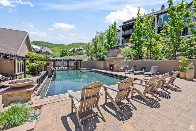 14234 S Canyon Vine Cv E, Draper, UT 84020 - view of swimming pool with a mountain view, an outdoor stone fireplace, and a patio