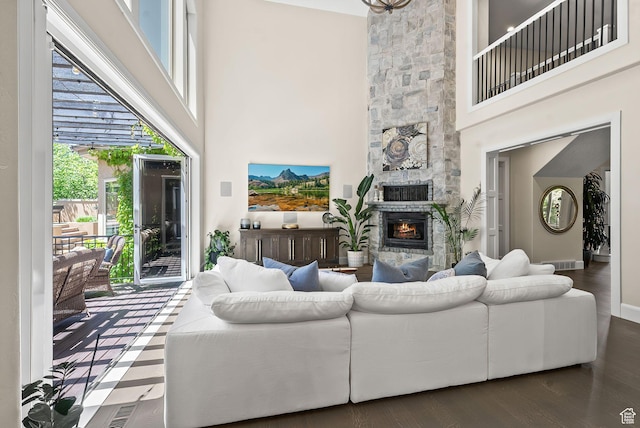 14234 S Canyon Vine Cv E, Draper, UT 84020 - living room with a stone fireplace, a towering ceiling, and dark wood-type flooring