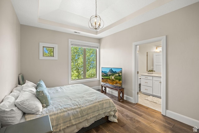 14234 S Canyon Vine Cv E, Draper, UT 84020 - bedroom featuring a raised ceiling, connected bathroom, a chandelier, and dark hardwood / wood-style floors
