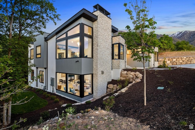 property exterior at dusk with a mountain view