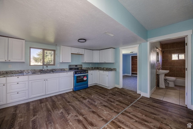 1090 S 2400 W, Lewiston, UT 84320 - kitchen featuring white cabinets, gas stove, a sink, stone countertops, and dark wood-style floors