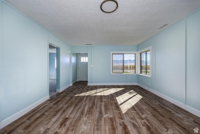 1090 S 2400 W, Lewiston, UT 84320 - unfurnished living room featuring baseboards, wood finished floors, and a textured ceiling