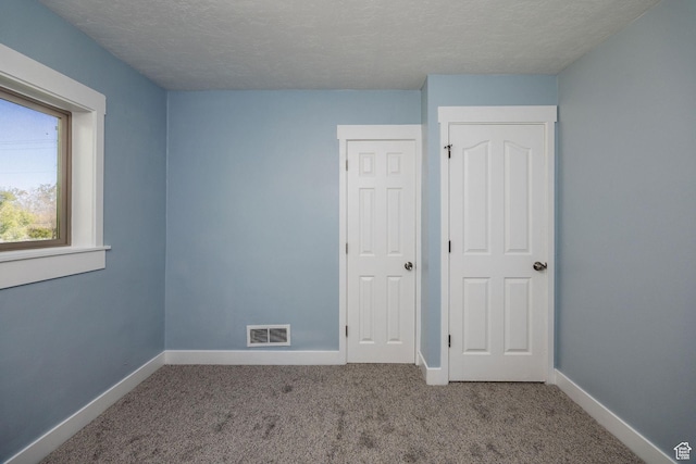 1090 S 2400 W, Lewiston, UT 84320 - unfurnished bedroom with baseboards, visible vents, carpet flooring, and a textured ceiling