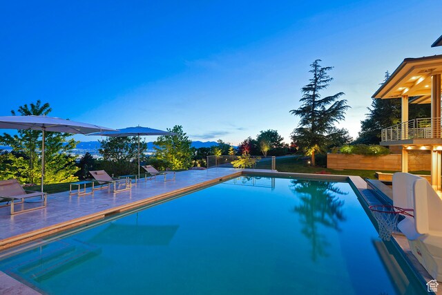 1559 E Tomahawk Dr N, Salt Lake City, UT 84103 - pool at dusk featuring a patio