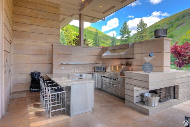 1559 E Tomahawk Dr N, Salt Lake City, UT 84103 - view of patio / terrace with a mountain view, a wet bar, exterior kitchen, and a grill