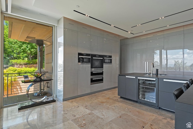 1559 E Tomahawk Dr N, Salt Lake City, UT 84103 - kitchen featuring sink, gray cabinetry, beverage cooler, and stainless steel double oven