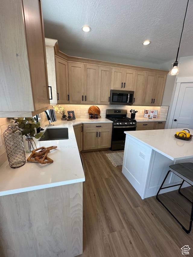 634 E Otto Ln, Grantsville, UT 84029 - kitchen with a sink, stainless steel appliances, dark wood-type flooring, light countertops, and backsplash
