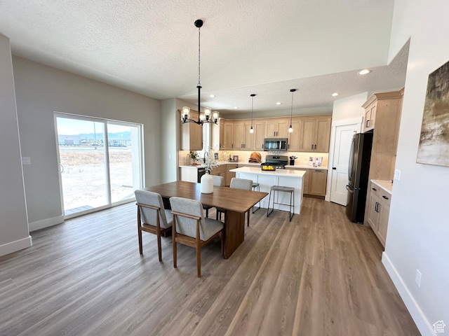 634 E Otto Ln, Grantsville, UT 84029 - dining room featuring light wood-type flooring, baseboards, a textured ceiling, and an inviting chandelier