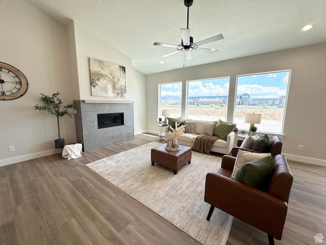 634 E Otto Ln, Grantsville, UT 84029 - living room featuring lofted ceiling, a ceiling fan, wood finished floors, baseboards, and a tile fireplace