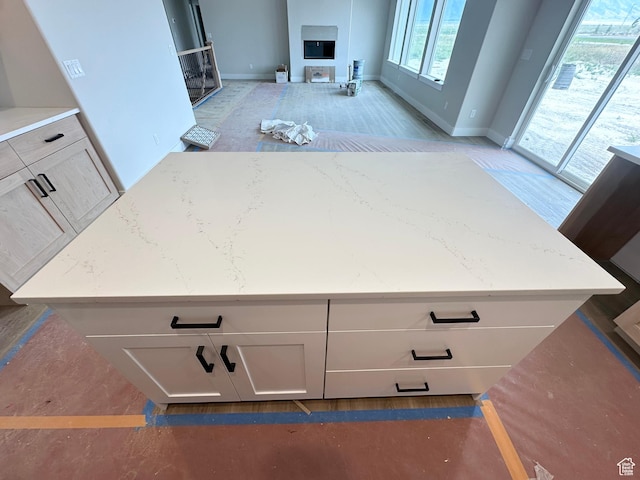 634 E Otto Ln, Grantsville, UT 84029 - kitchen featuring baseboards, light stone countertops, white cabinets, and a center island