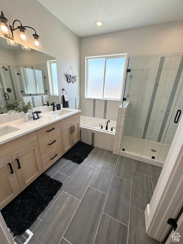 634 E Otto Ln, Grantsville, UT 84029 - bathroom with double vanity, a stall shower, a sink, a textured ceiling, and a garden tub
