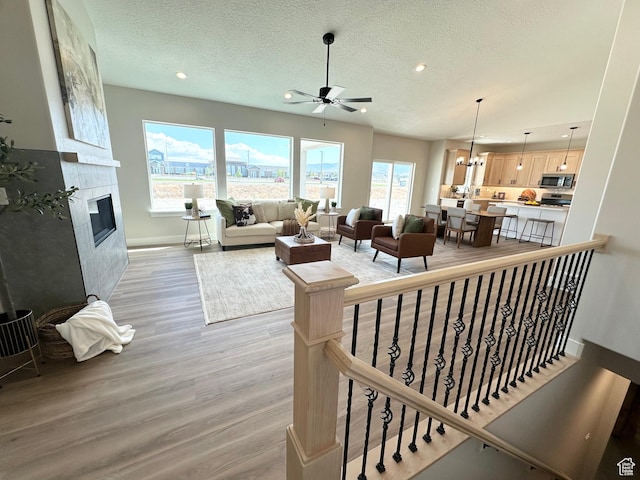 634 E Otto Ln, Grantsville, UT 84029 - living room with recessed lighting, a fireplace, light wood finished floors, and a textured ceiling